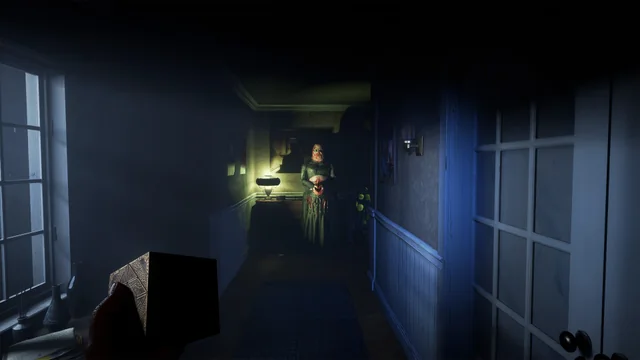 A dimly lit Labyrinth corridor in Clive Barker's Hellraiser: Revival lit by a single warm light source.